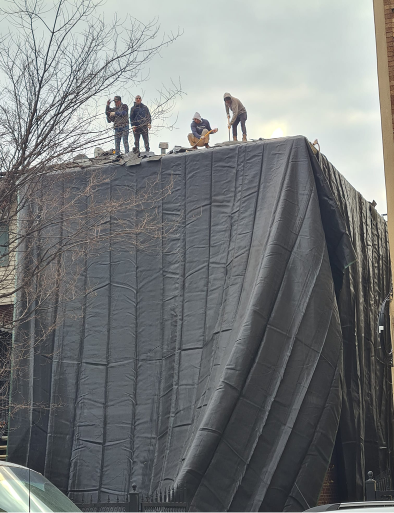 A couple of roofers working on a project in the Bronx.