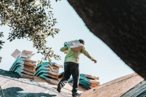 Construction worker carrying roofing materials 
