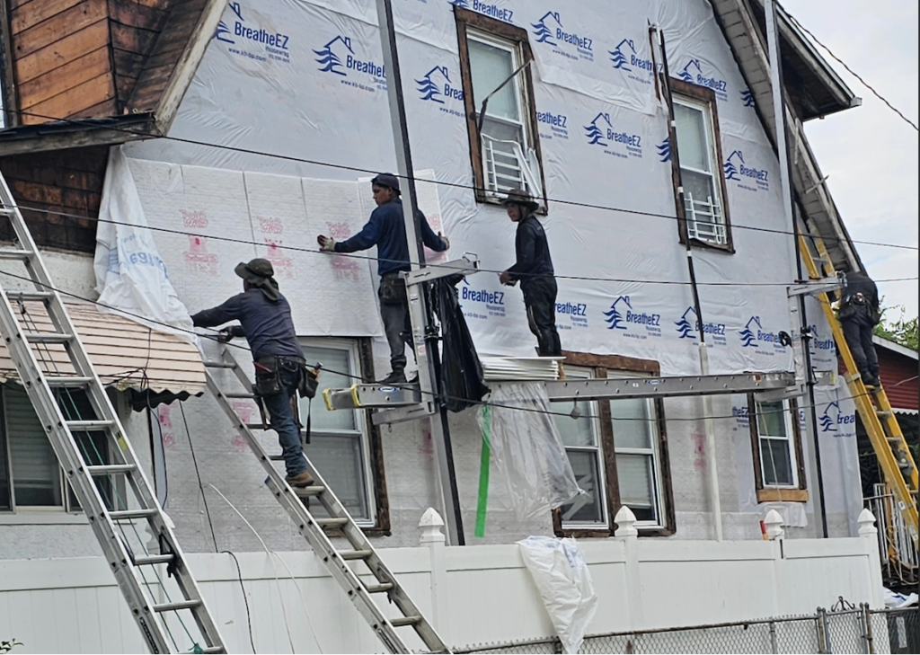 Construction workers renovating house exterior