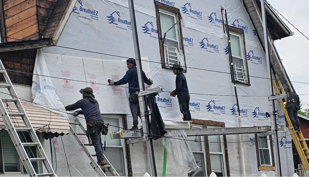 Construction workers renovating house exterior