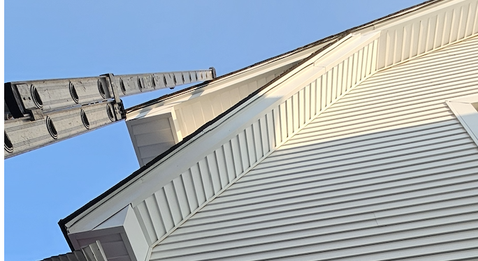 Low-angle view of a white vinyl-sided house