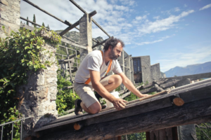 A man building roof of wooden construction