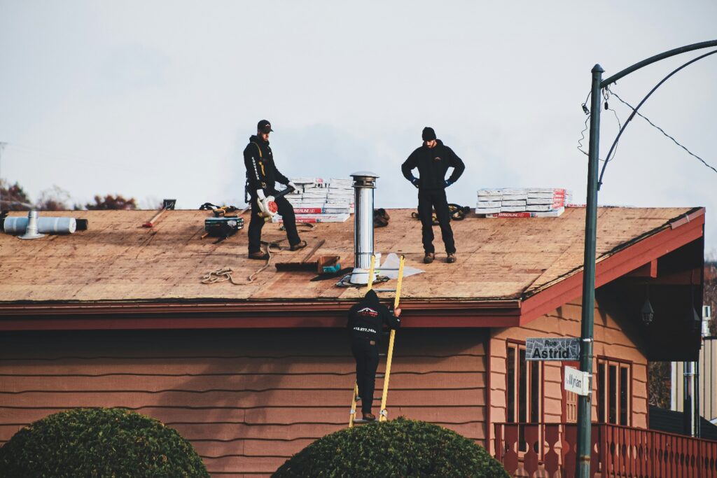 image of two contractors on a roof with equipment