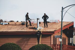 image of two contractors on a roof with equipment